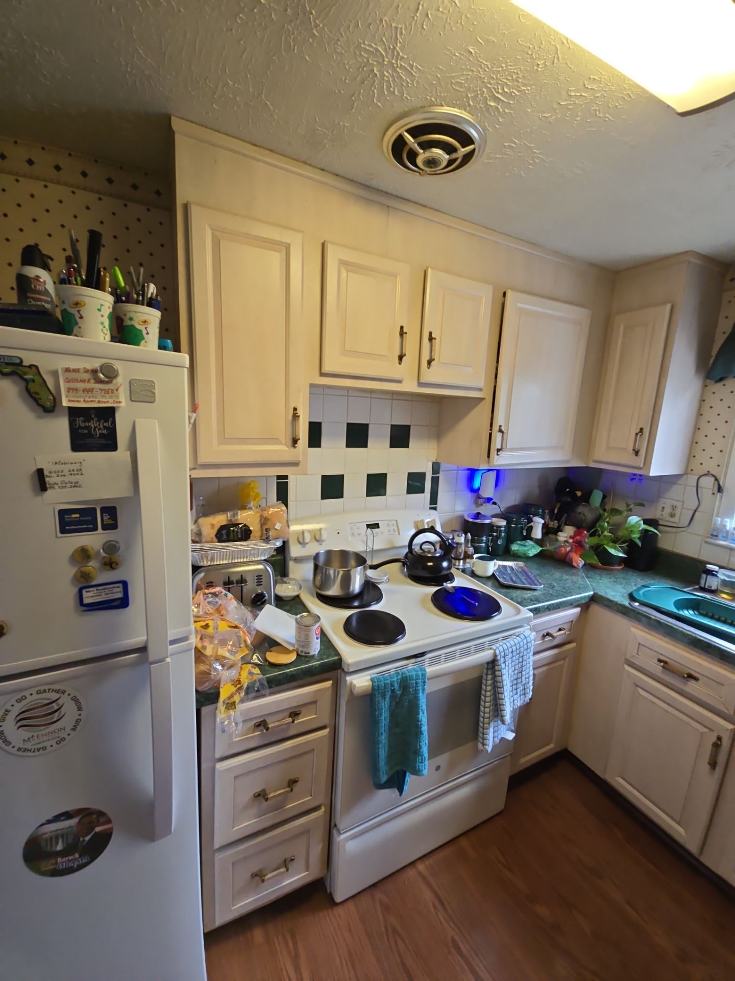 A kitchen with white cabinets and a white refrigerator
