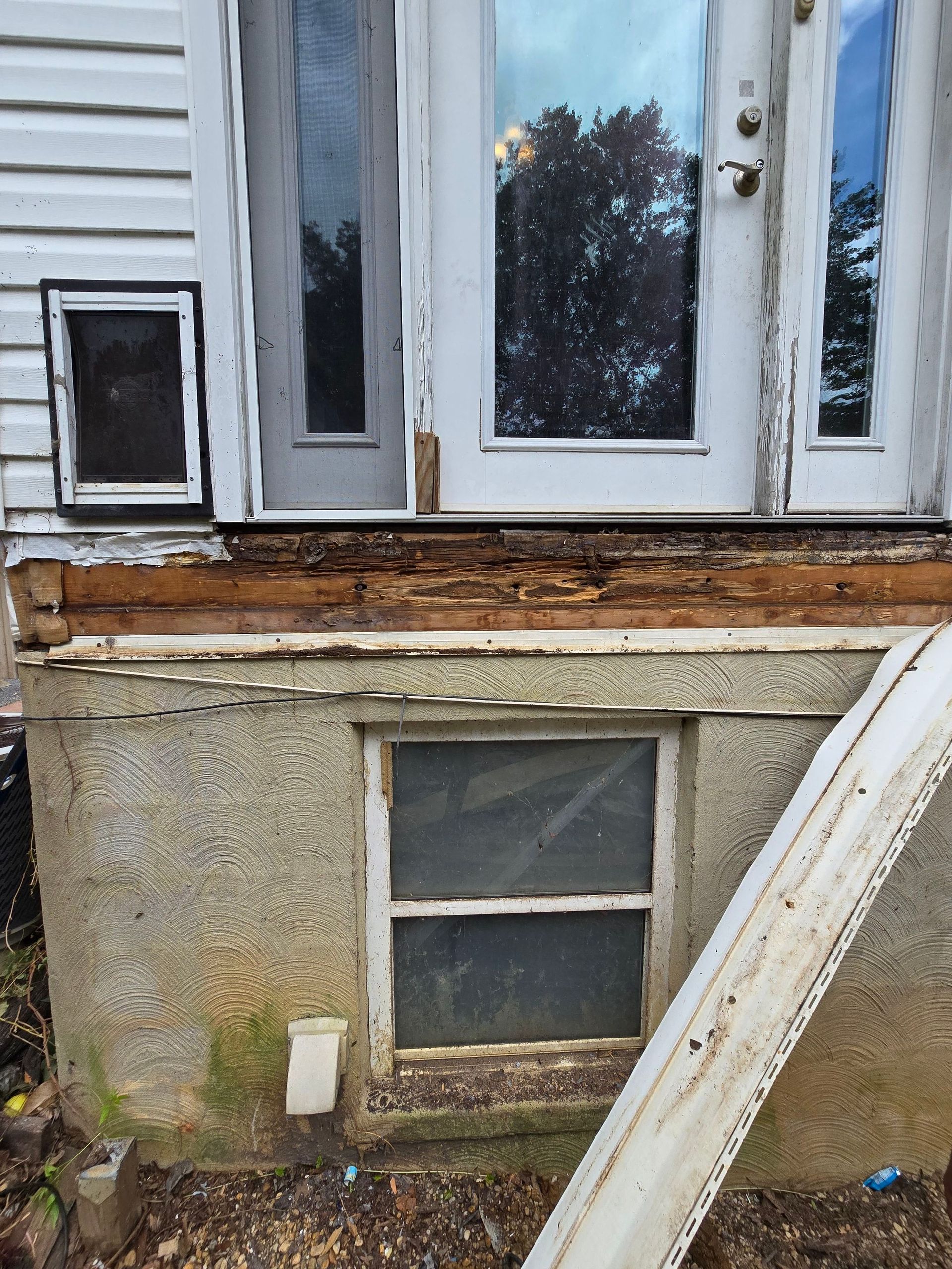 A white house with a dog door and a window