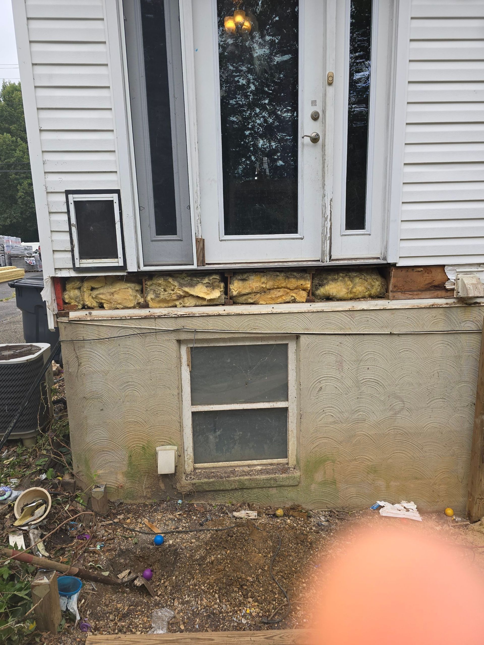 A white house with a window and a dog door.