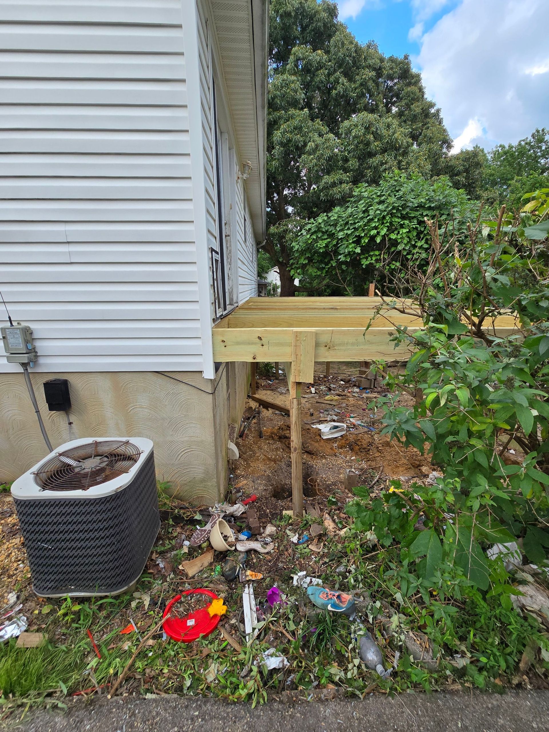 A wooden deck is being built on the side of a house.
