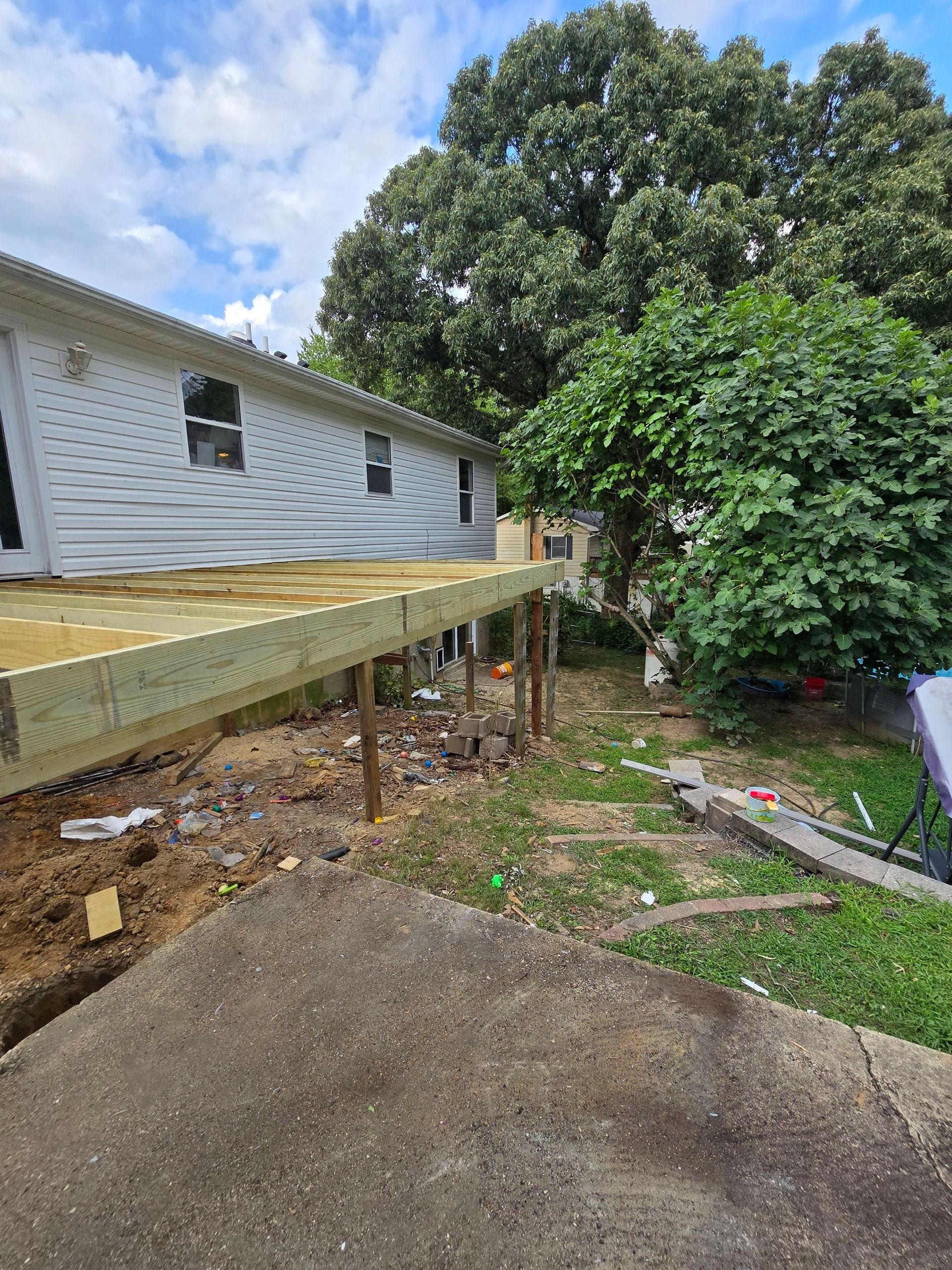 A wooden deck is being built in front of a house.