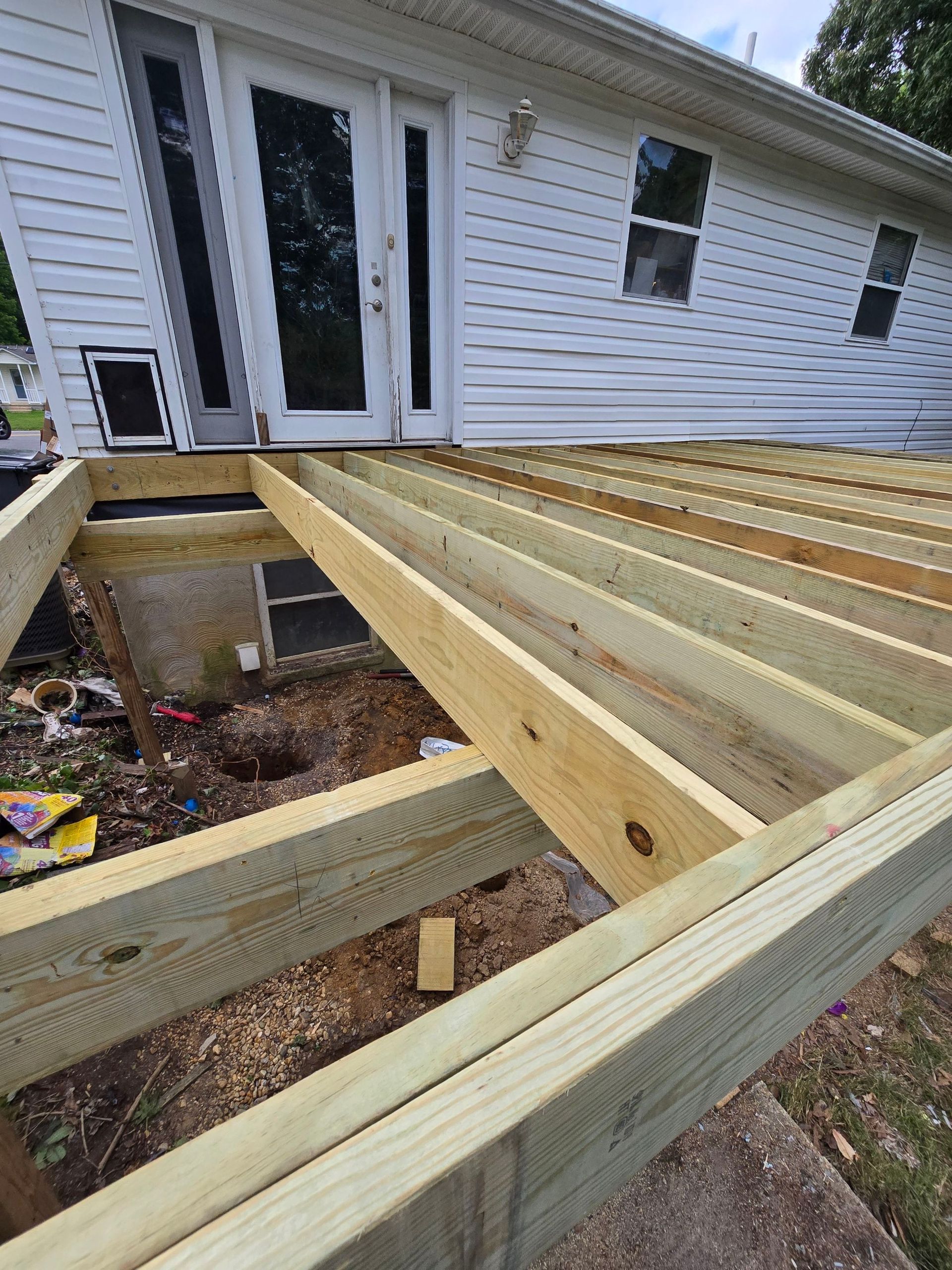 A wooden deck is being built in front of a house.