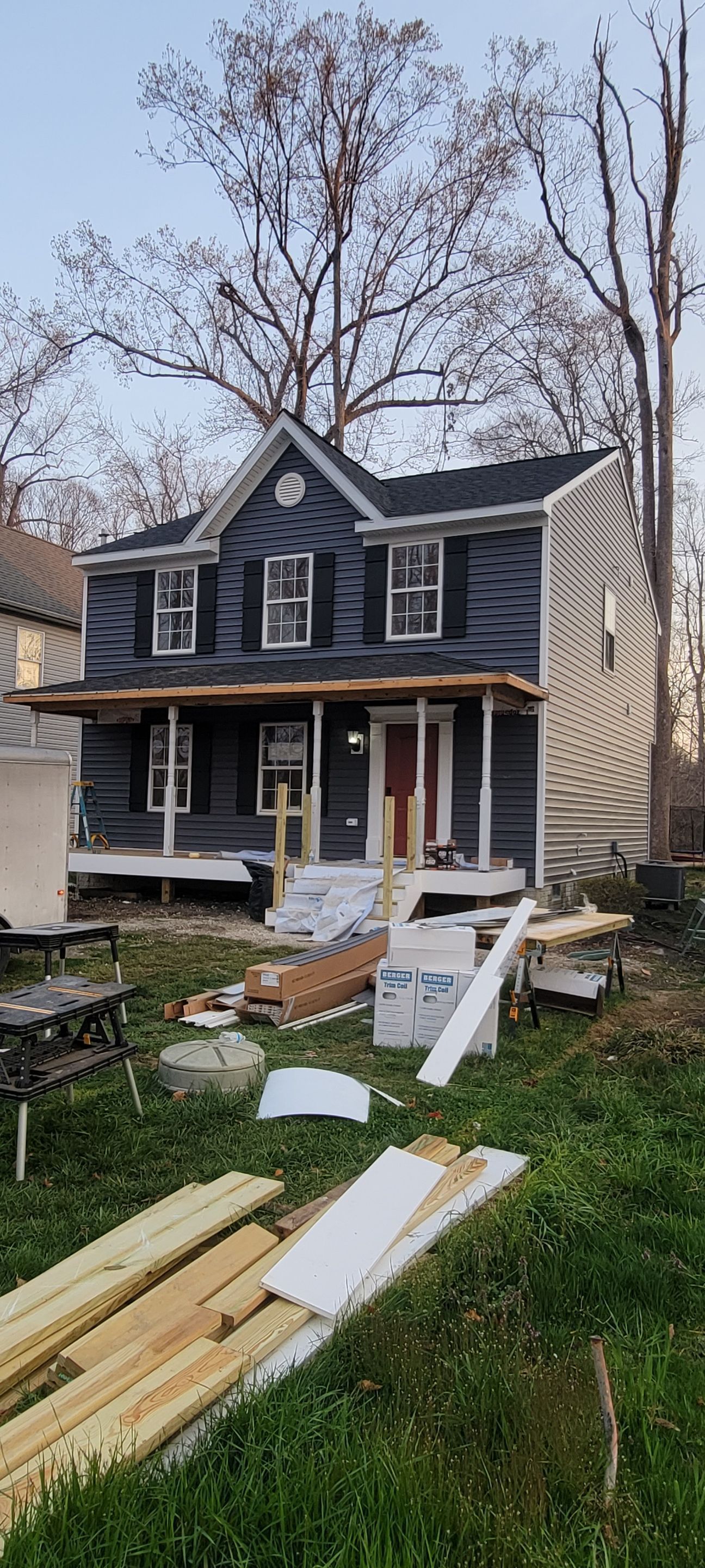 A house under construction with a lot of wood in front of it.