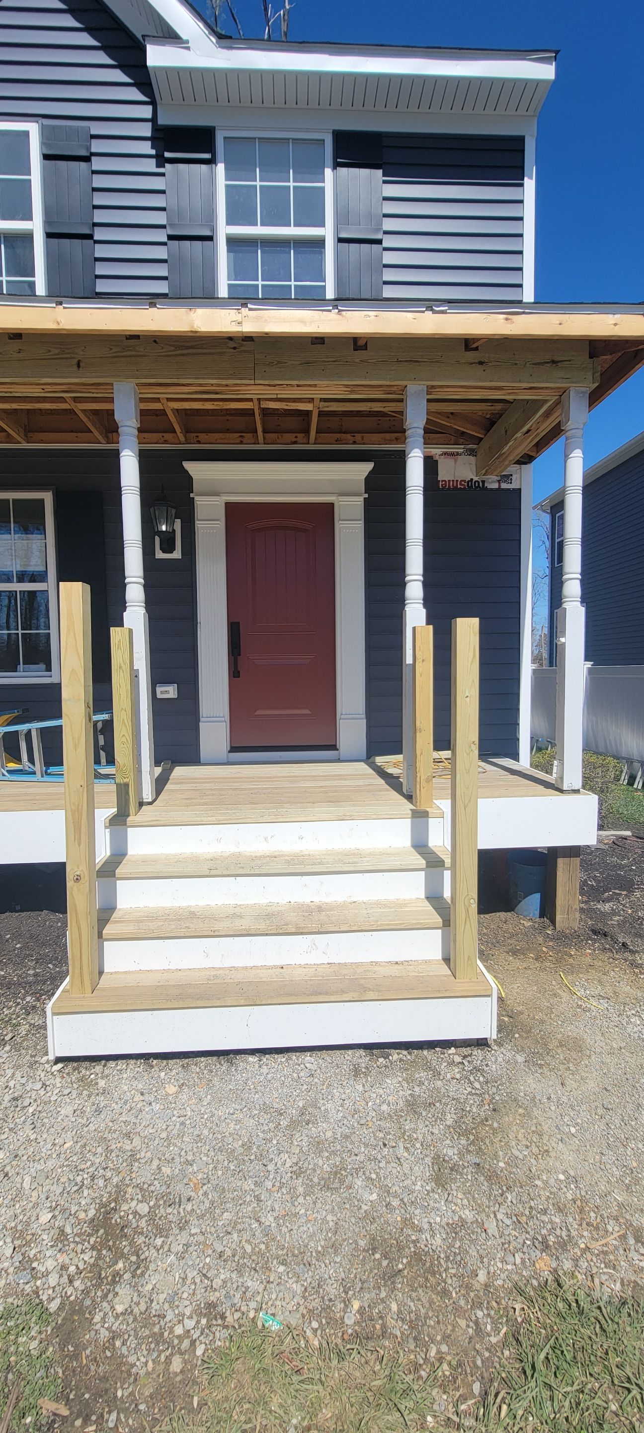 A house with a porch and stairs under construction.