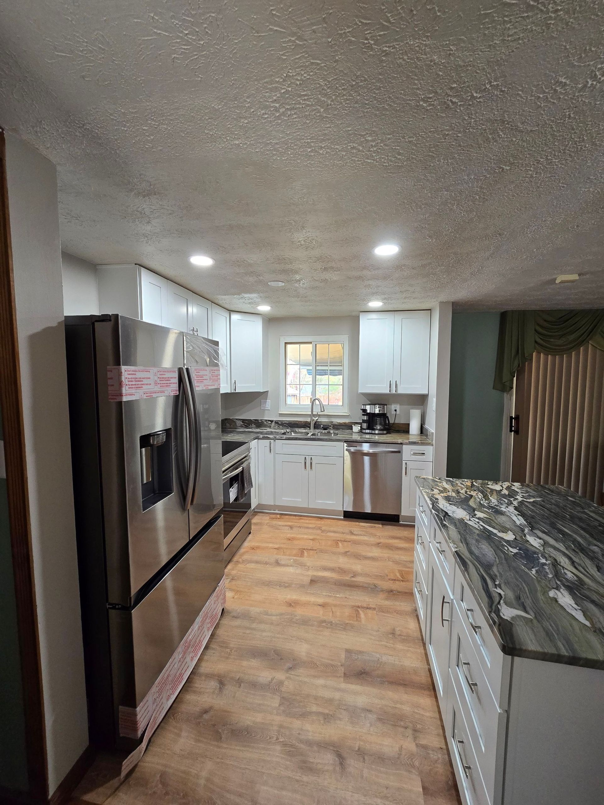 A kitchen with stainless steel appliances and white cabinets.
