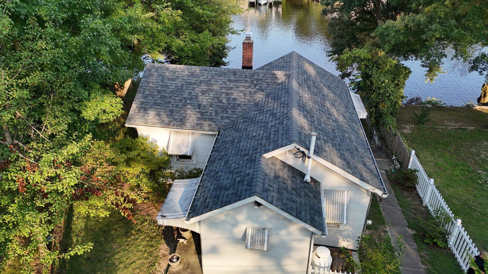 An aerial view of a house that is surrounded by water.
