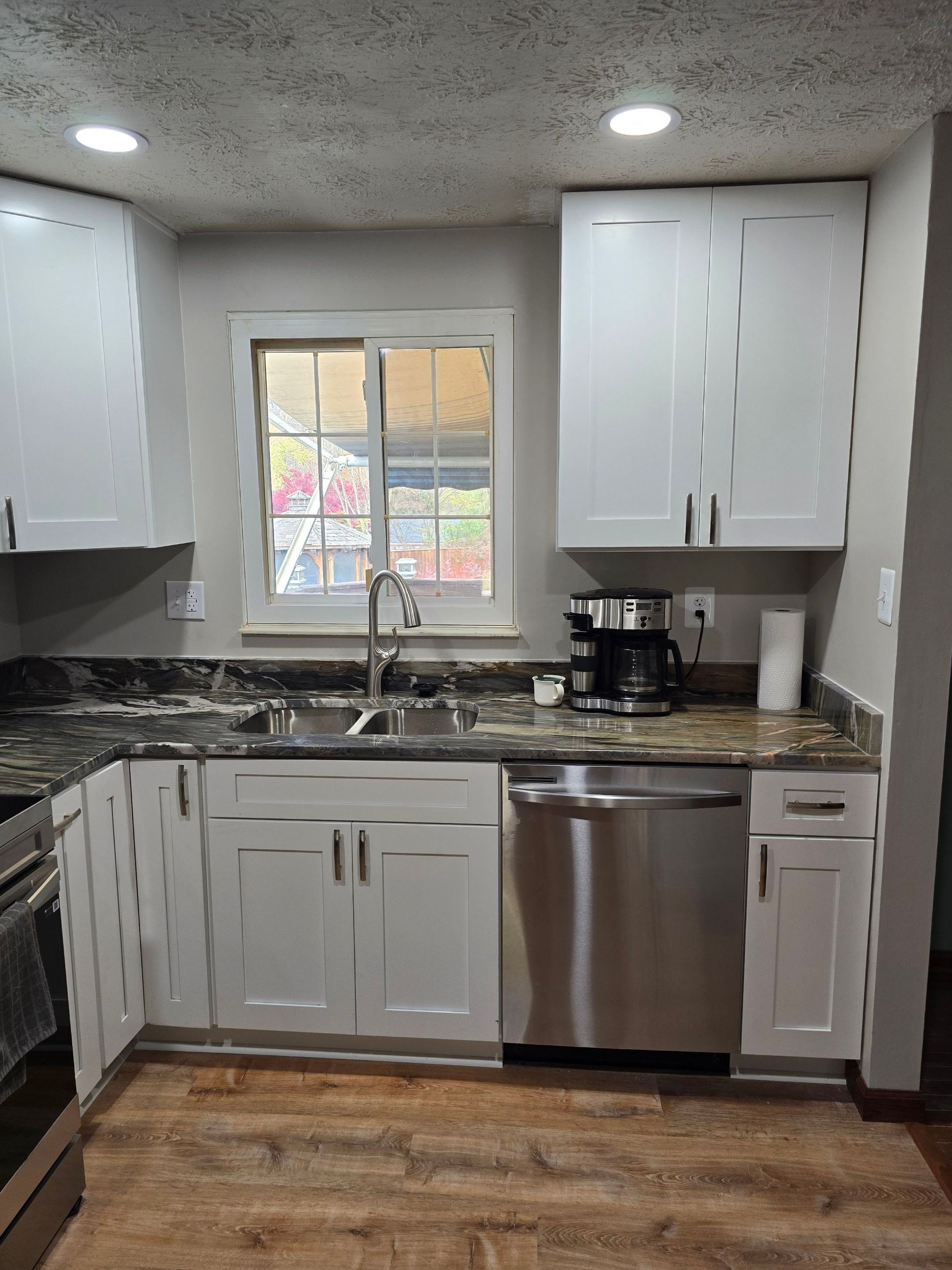 A kitchen with white cabinets and stainless steel appliances