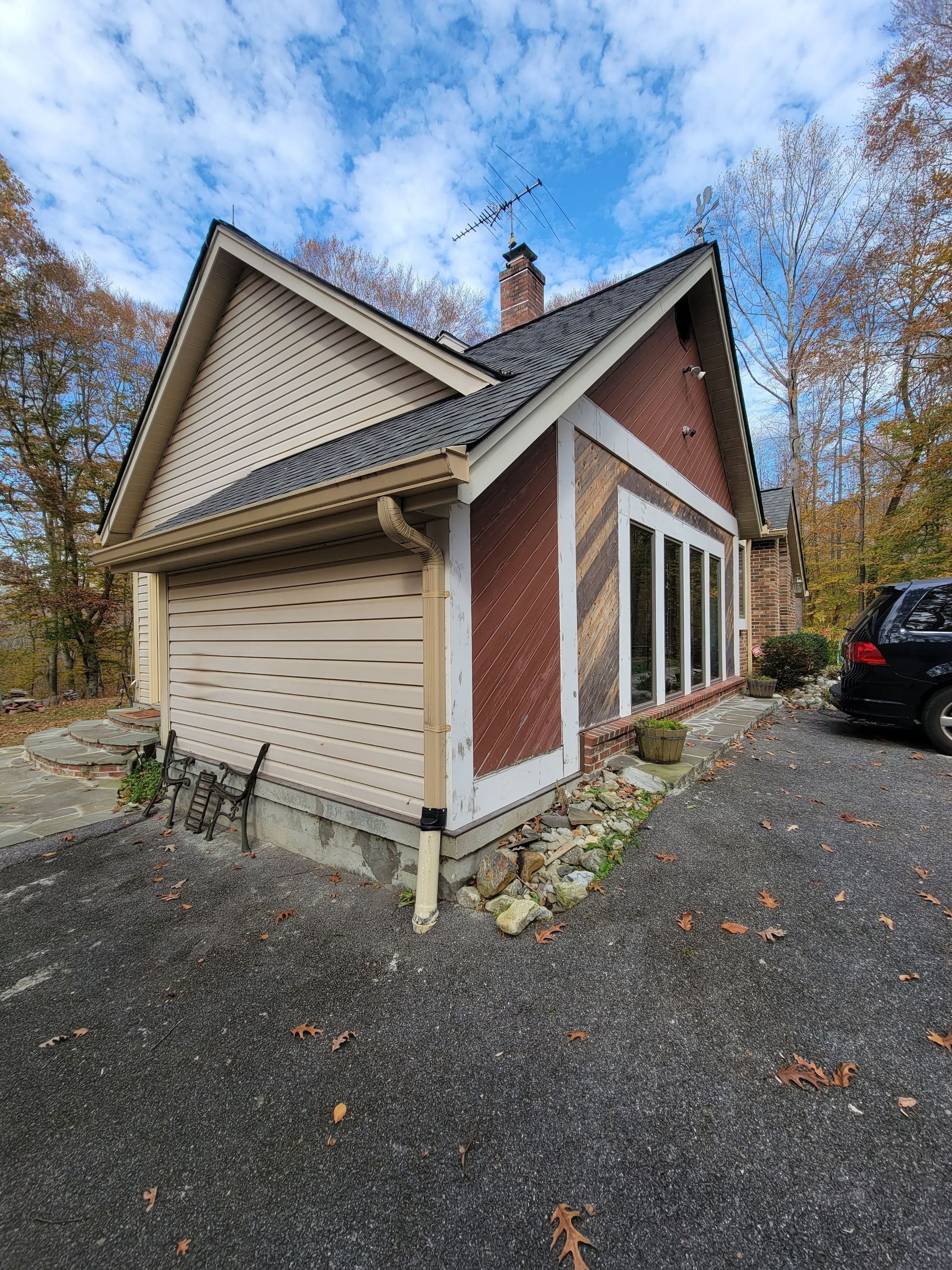 A small house with a car parked in front of it.