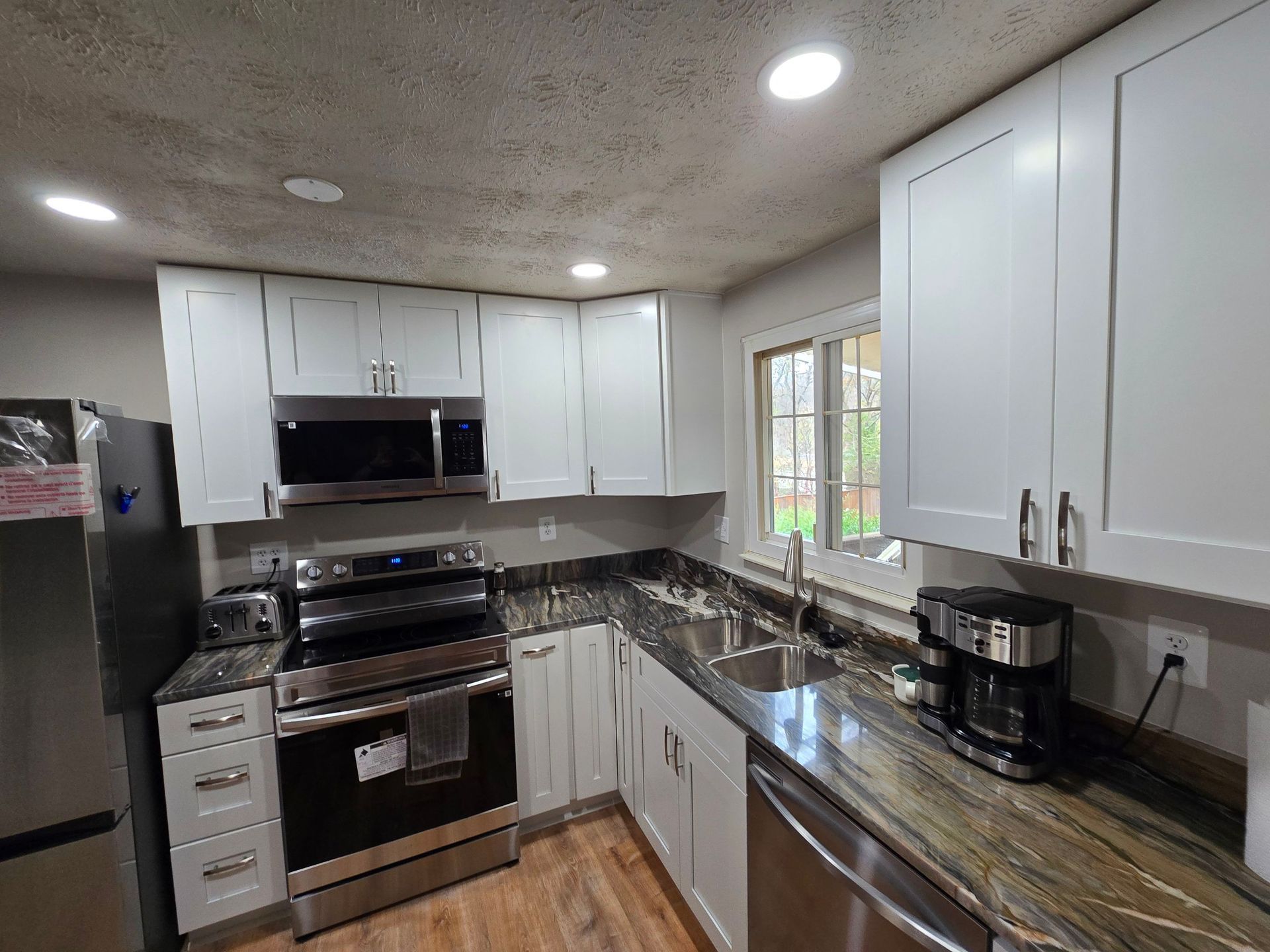 A kitchen with stainless steel appliances and white cabinets.