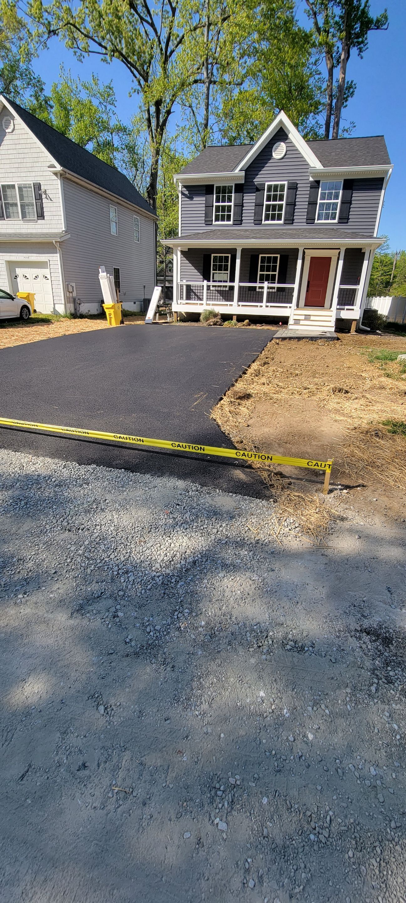 A house with a driveway that is being paved in front of it.