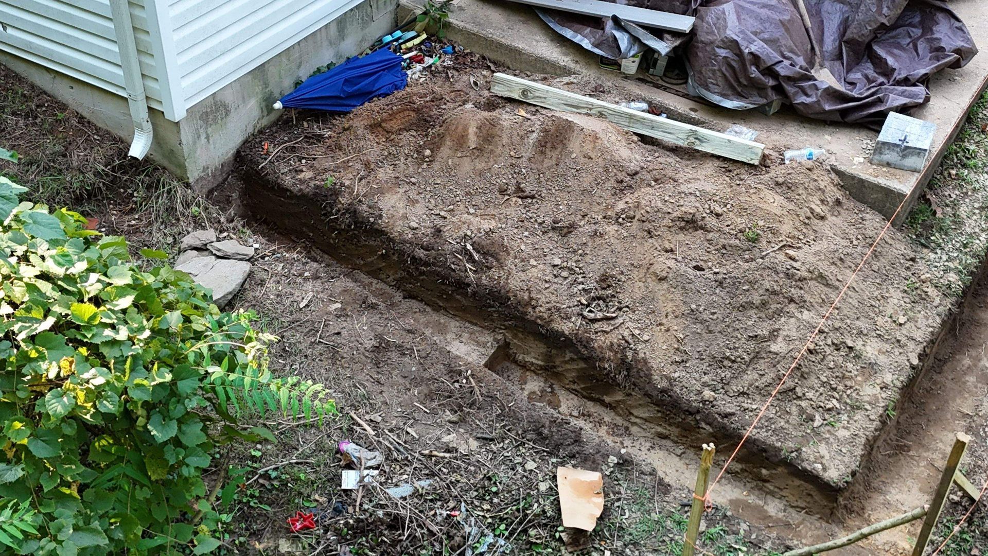 A pile of dirt is sitting in front of a house.