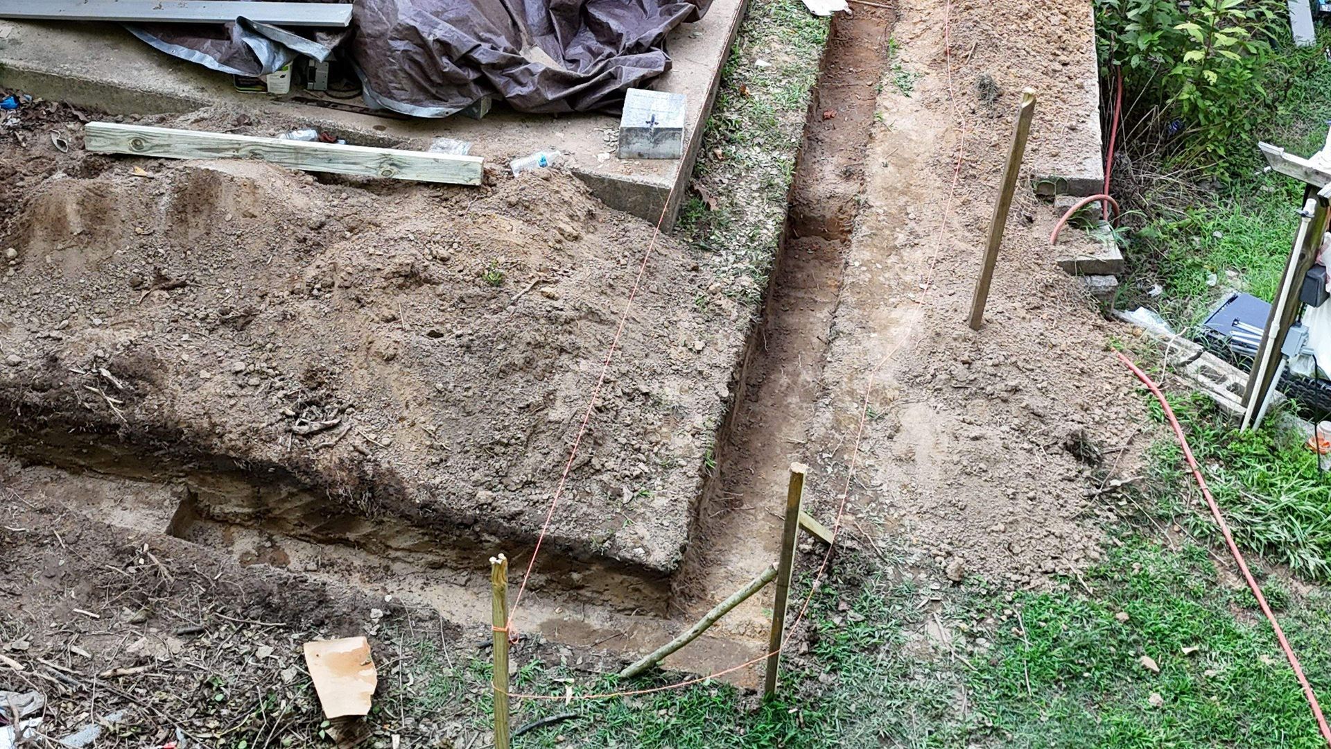 A pile of dirt is sitting on top of a grass covered field.