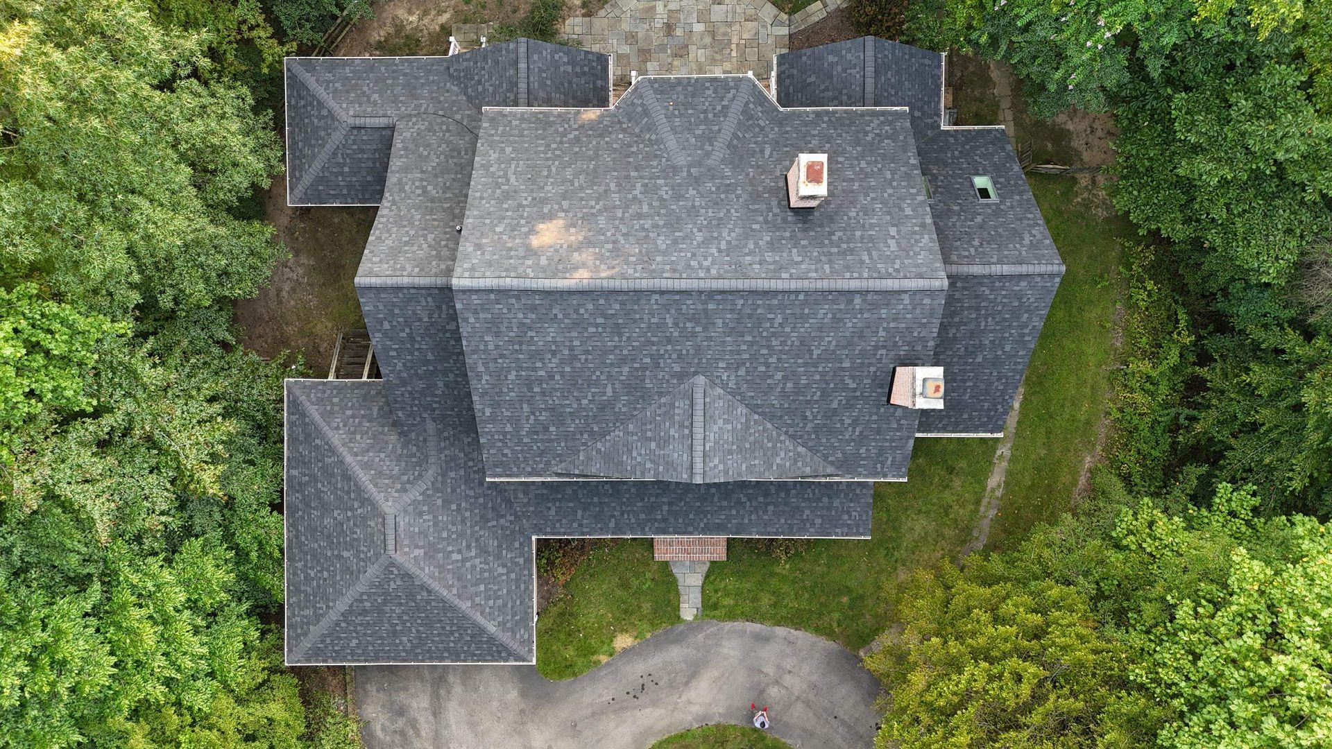 An aerial view of a large house surrounded by trees.