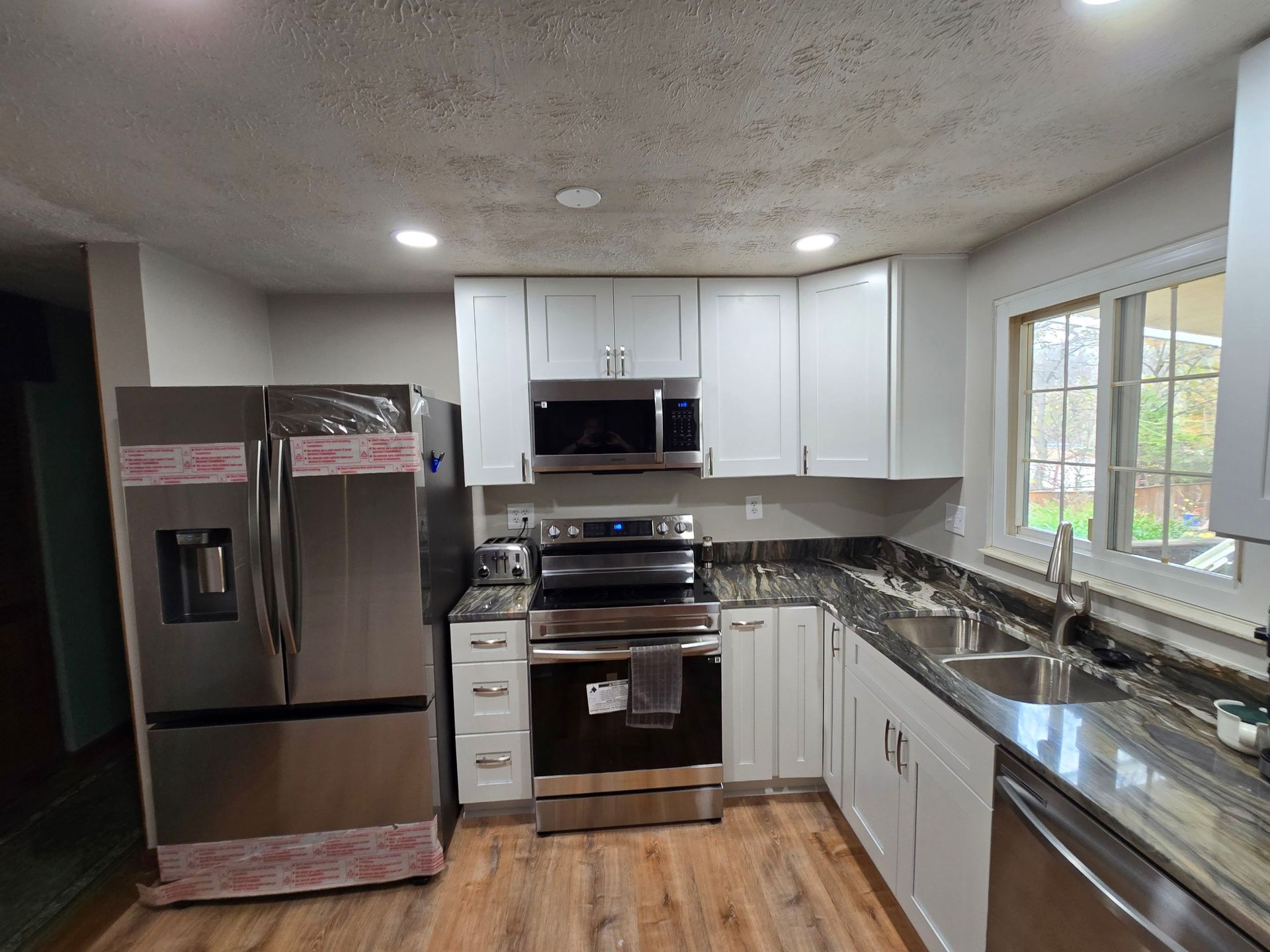 A kitchen with stainless steel appliances and white cabinets