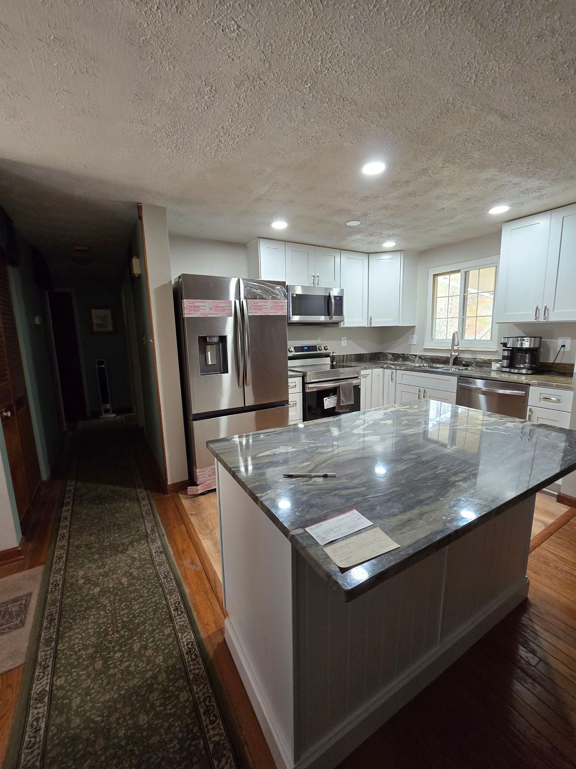 A kitchen with stainless steel appliances and granite counter tops.