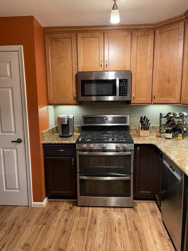 A kitchen with stainless steel appliances and wooden cabinets