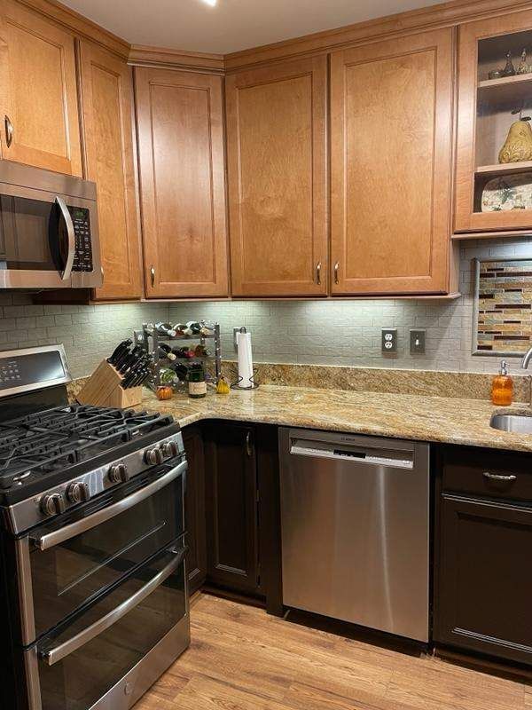 A kitchen with stainless steel appliances and wooden cabinets.