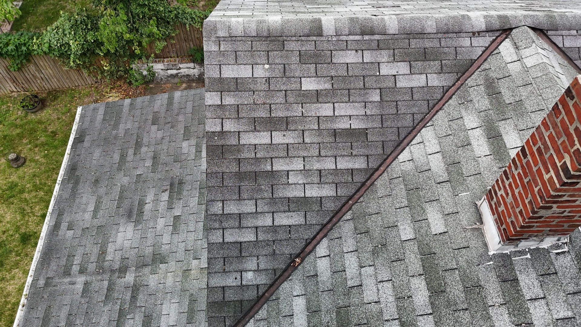 An aerial view of a roof with shingles and a chimney.