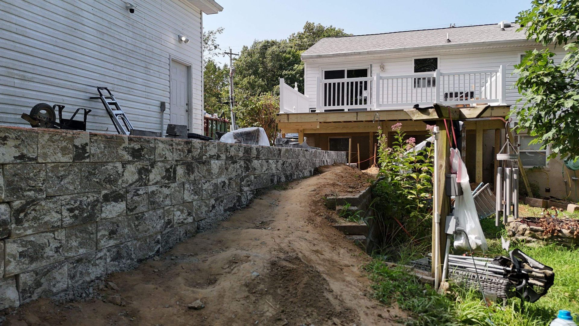 A stone wall is being built in front of a house.