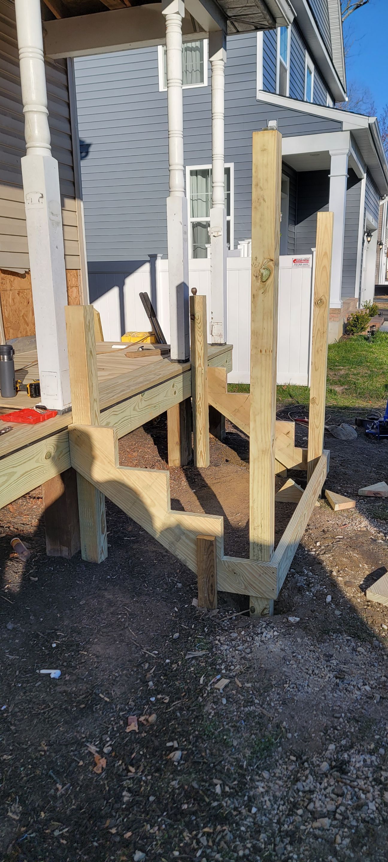 A wooden deck is being built in front of a house.
