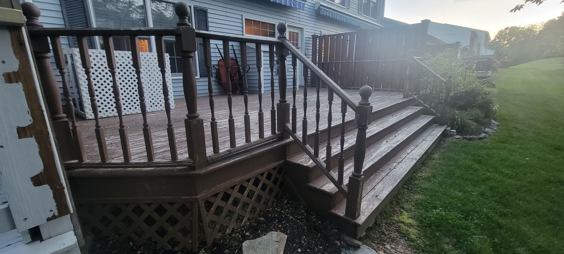 A wooden deck with stairs leading up to a house.