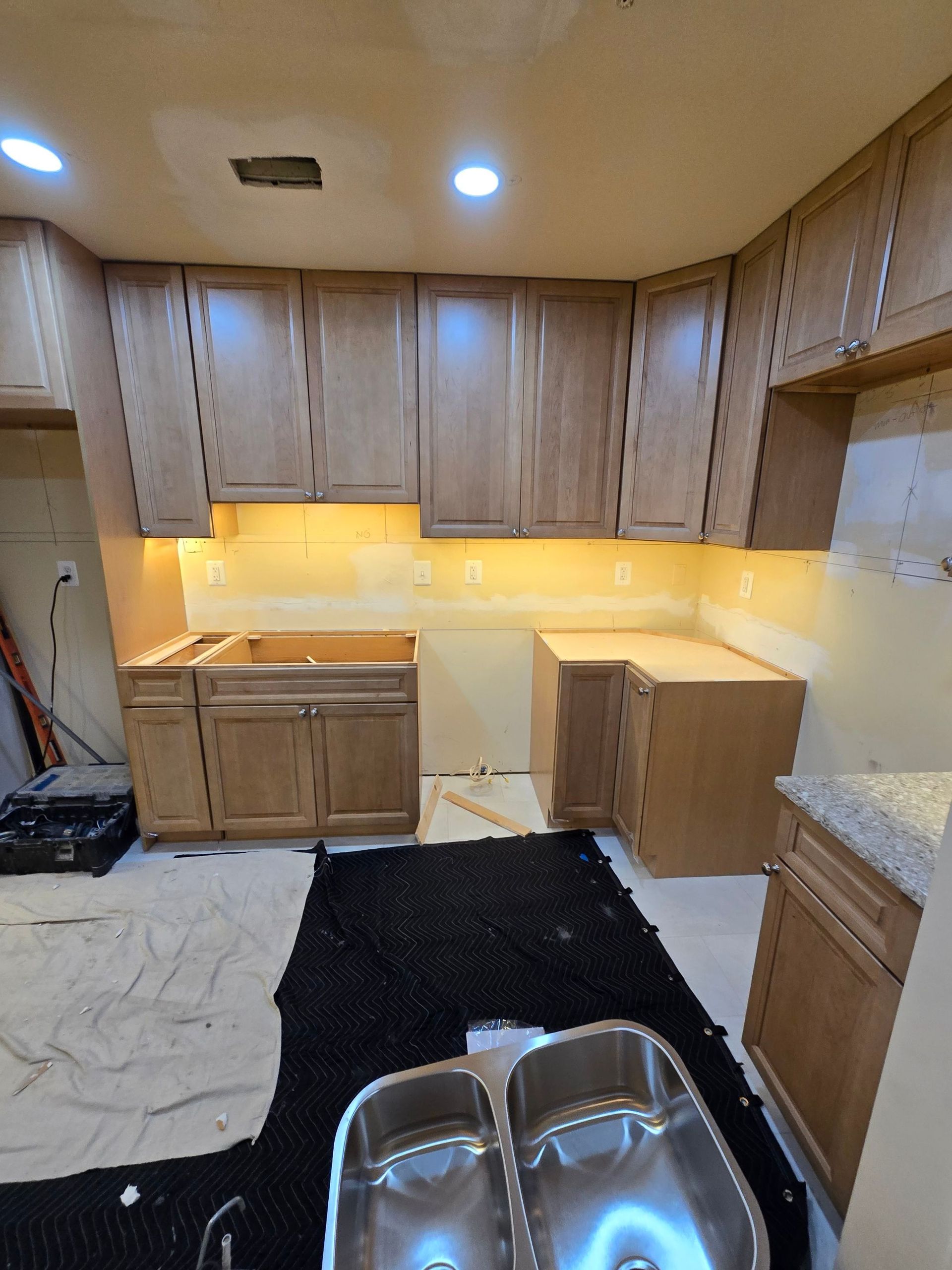 A kitchen with wooden cabinets and stainless steel sinks