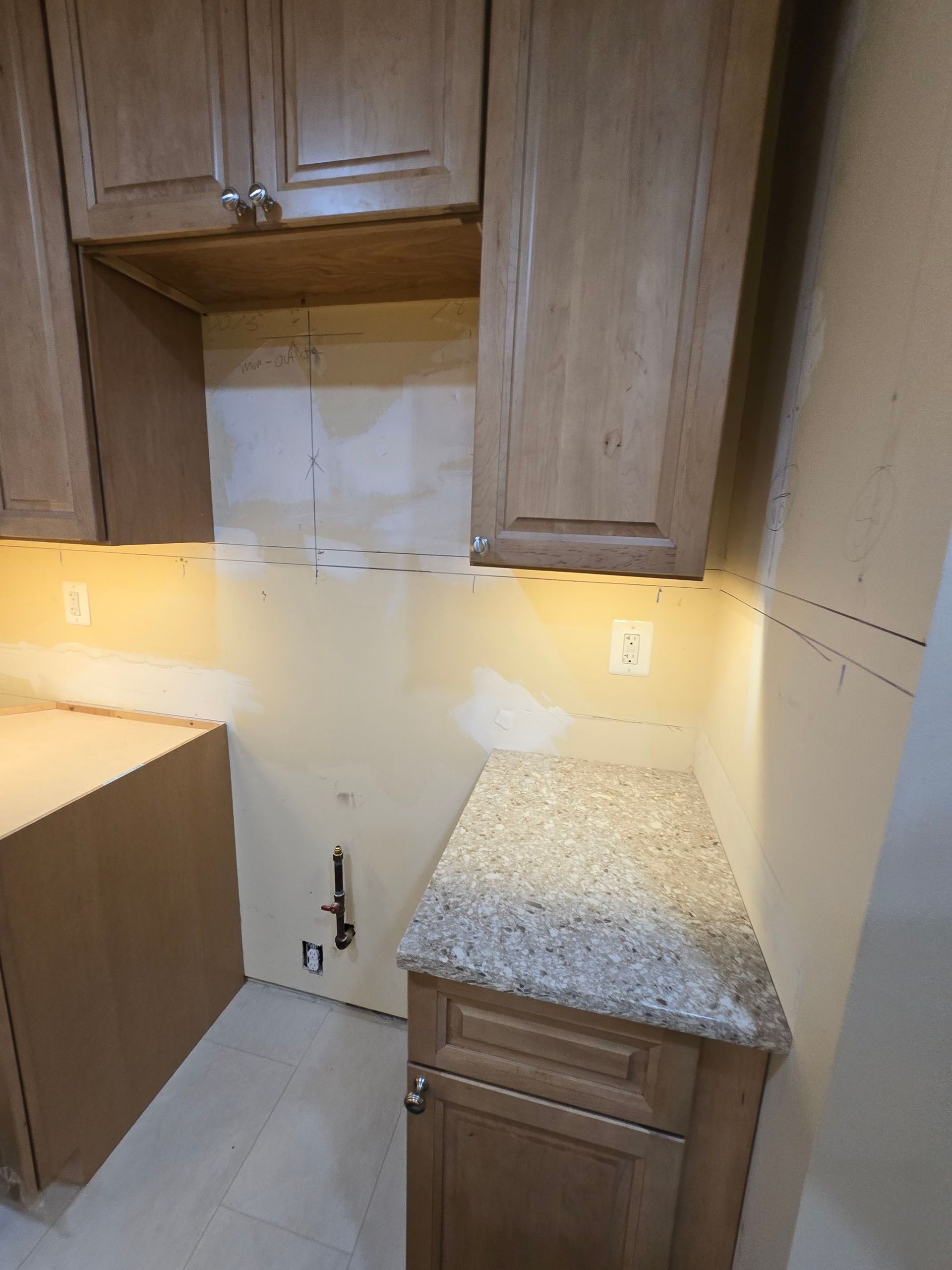 A kitchen with wooden cabinets and a granite counter top.