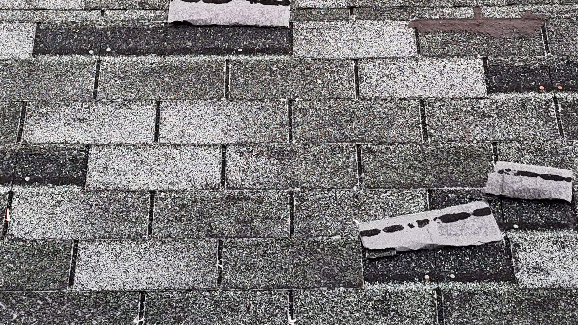 A close up of a roof with a lot of shingles missing.