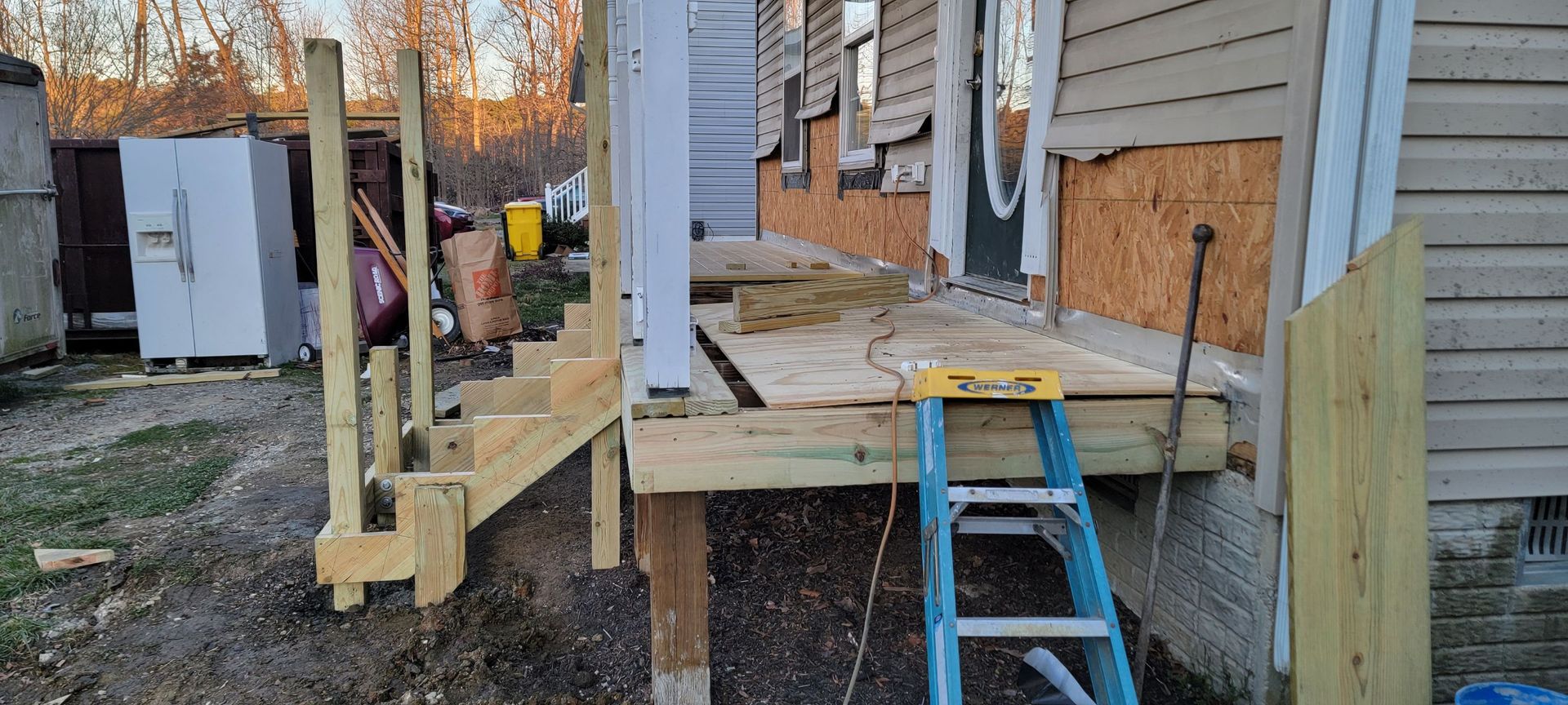 A wooden deck is being built on the side of a house.