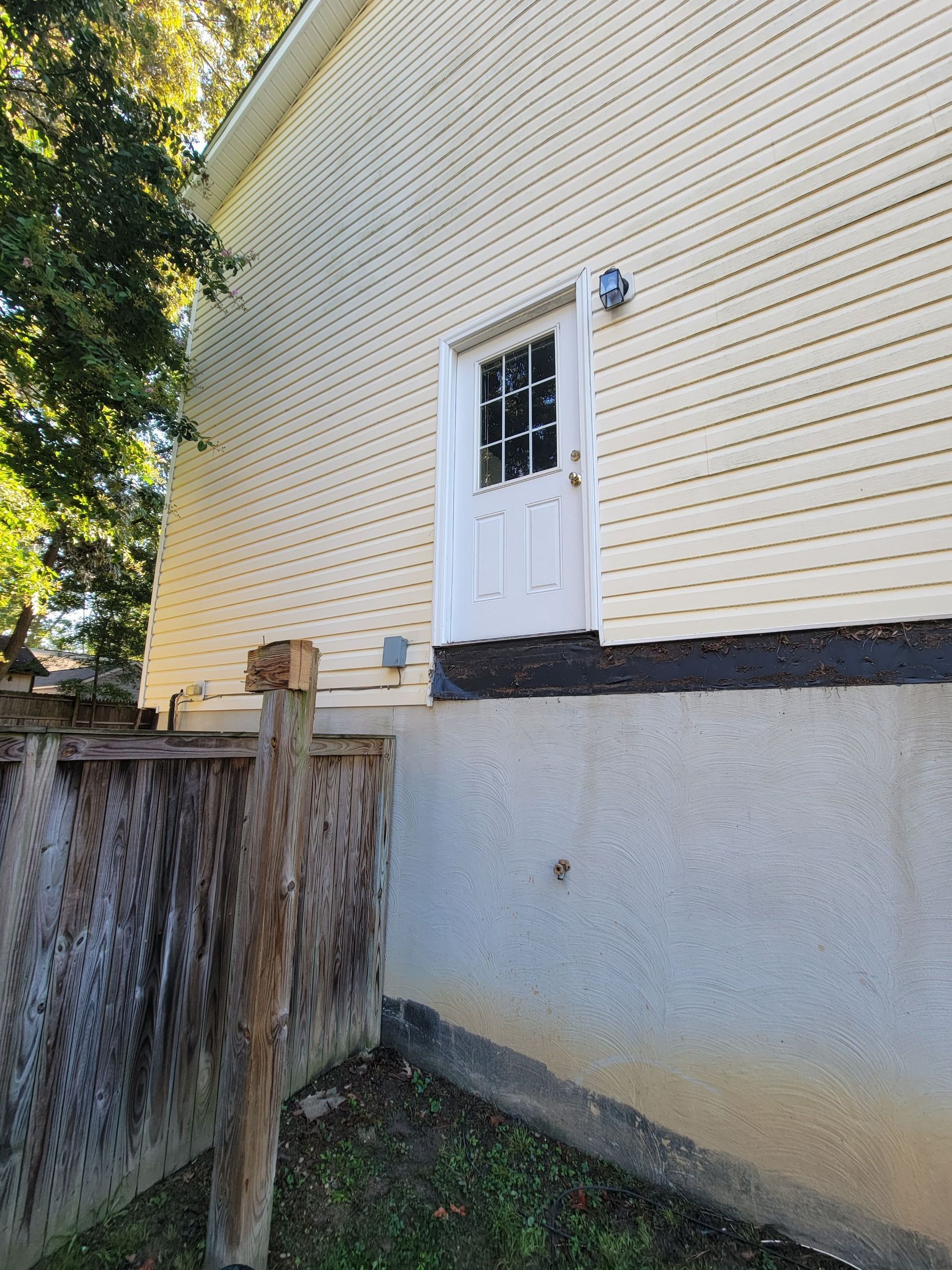 A house with a white door and a wooden fence in front of it.