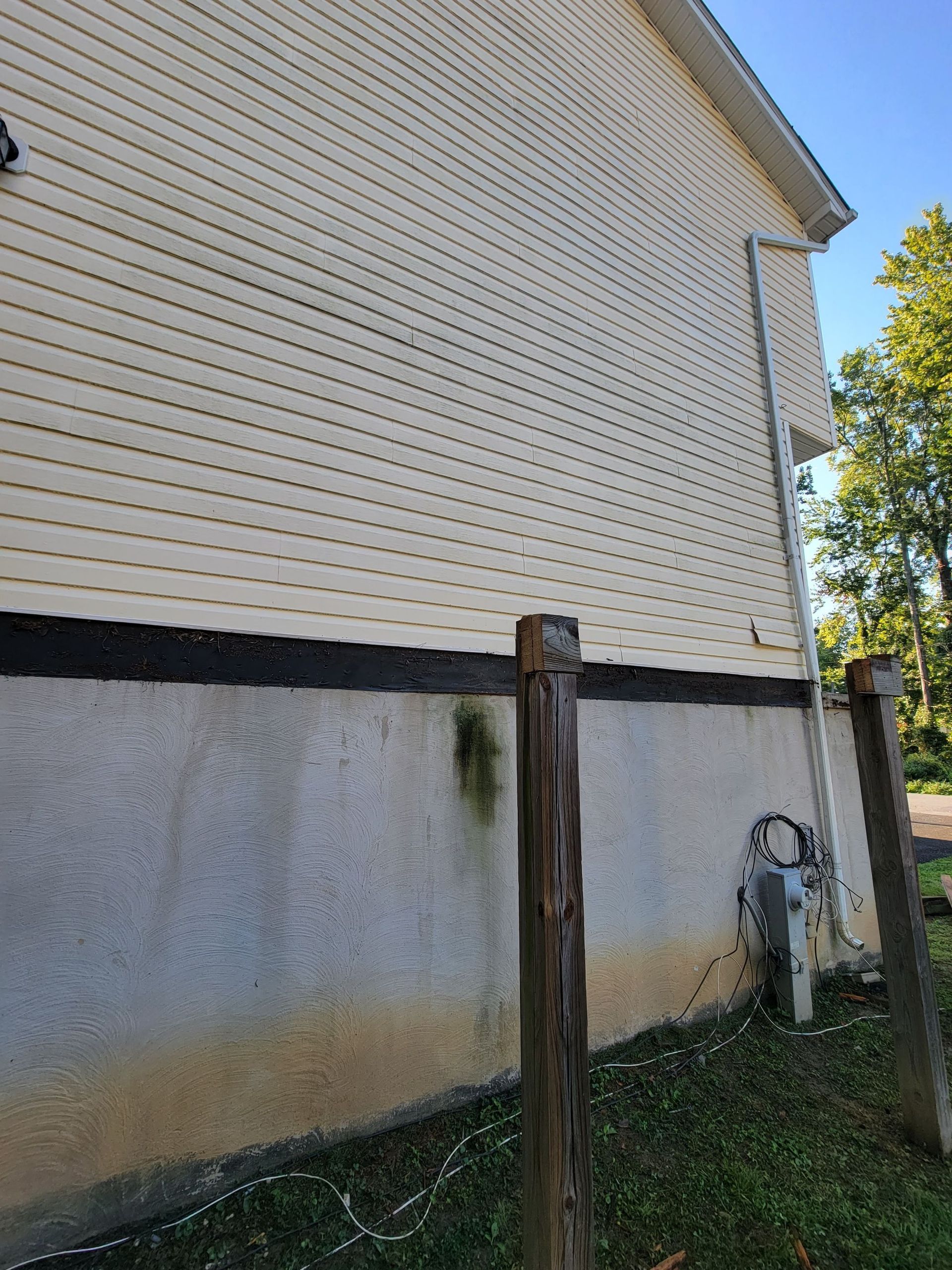 The side of a house with a wooden fence in front of it.