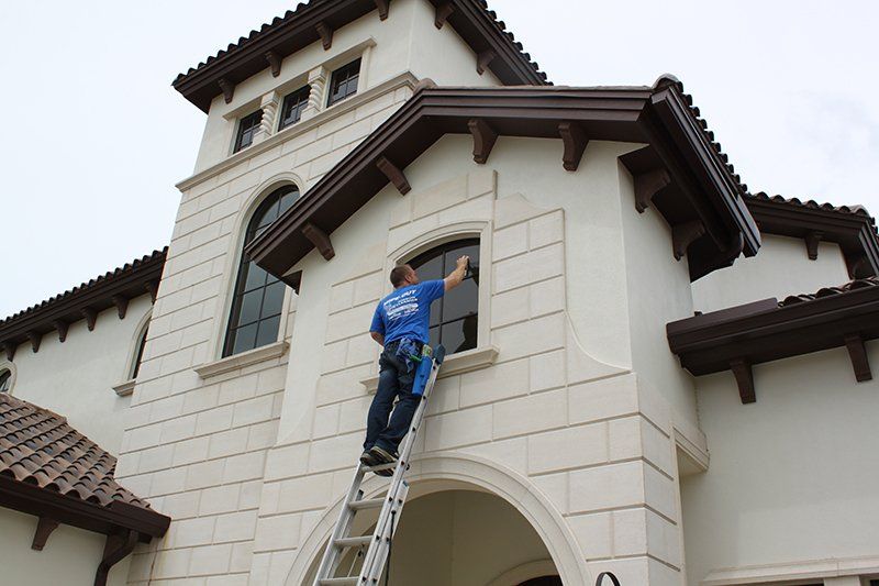 Man Using Stairs and Cleaning House Window — Fort Myers, FL — Wipe Out Windows
