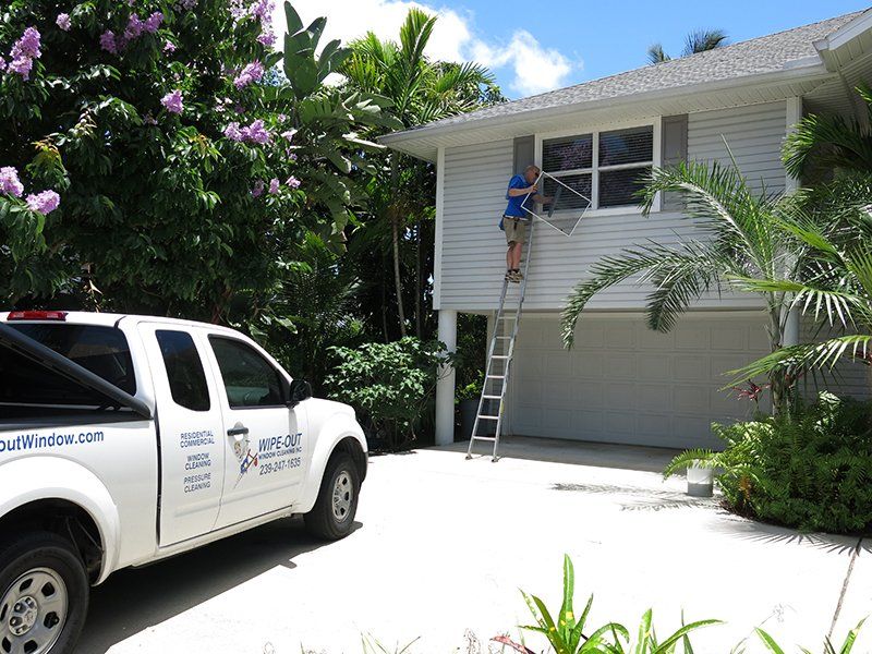 Wipe Out Windows Service Truck in Front of A House — Fort Myers, FL — Wipe Out Windows
