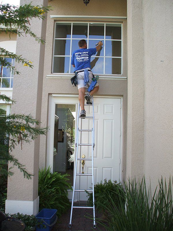 Man Cleaning House Window — Fort Myers, FL — Wipe Out Windows