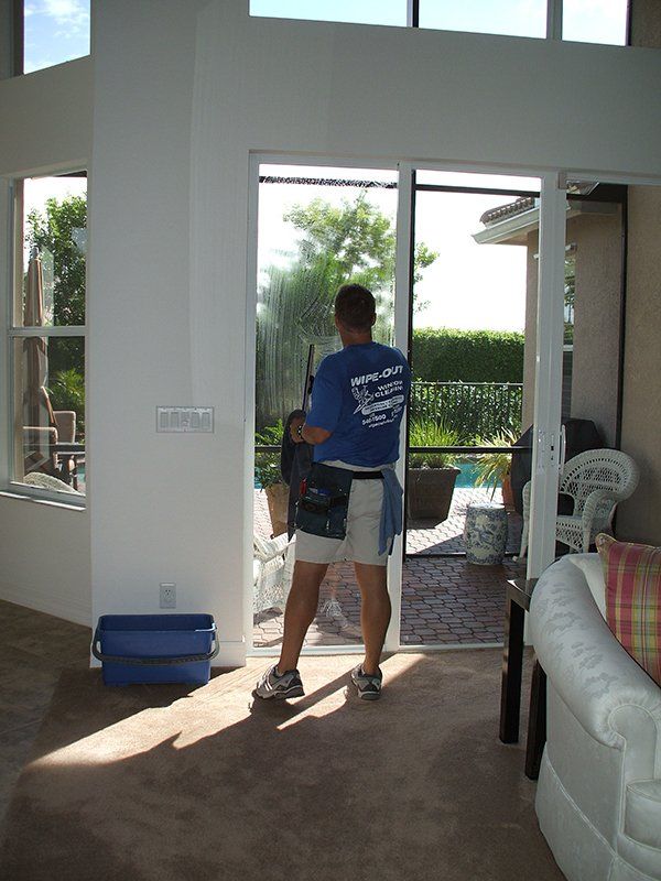 Man Cleaning Glass Door of Residential House — Fort Myers, FL — Wipe Out Windows