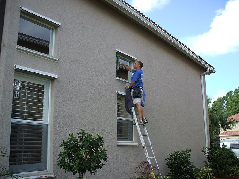 Man Cleaning Small Windows of Home — Fort Myers, FL — Wipe Out Windows
