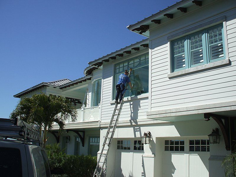 Man Using Stairs and Cleaning Windows of Home — Fort Myers, FL — Wipe Out Windows