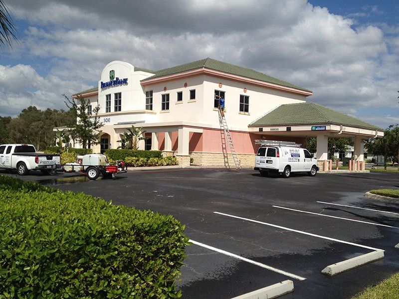 Wipe Out Windows Staff Cleaning Windows of Bank — Fort Myers, FL — Wipe Out Windows