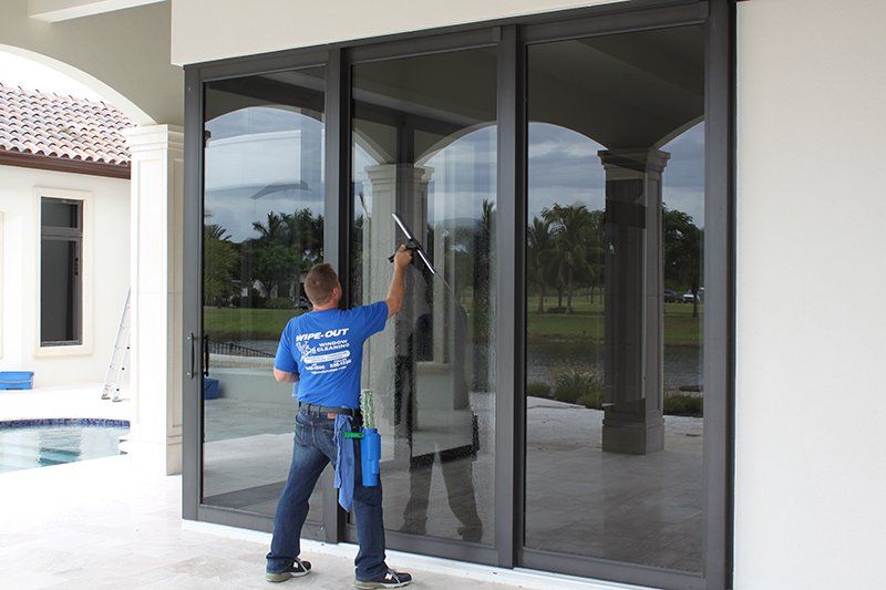 Man Cleaning Glass Door — Fort Myers, FL — Wipe Out Windows