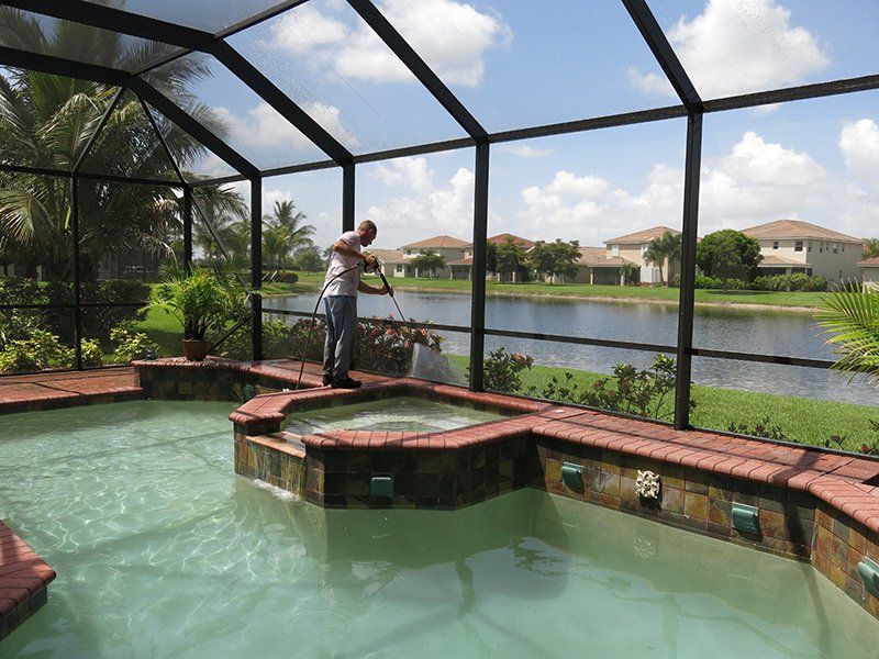 Man Cleaning Pool Pathway — Fort Myers, FL — Wipe Out Windows