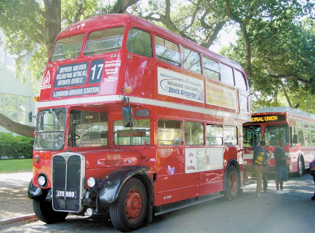 photo of two women looking at a phone while riding a bus