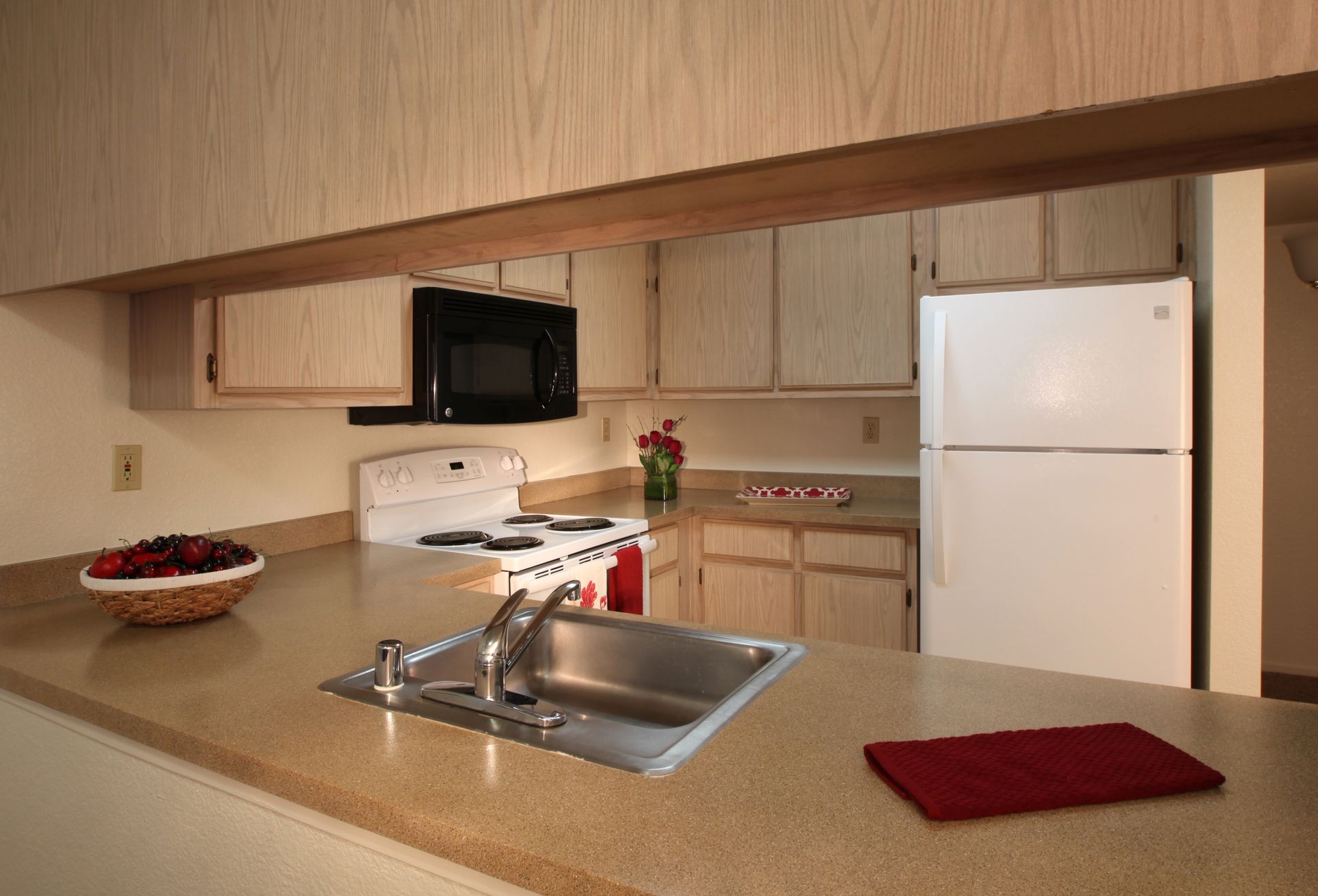 Kitchen with beige cabinets, white appliances, and a breakfast bar.