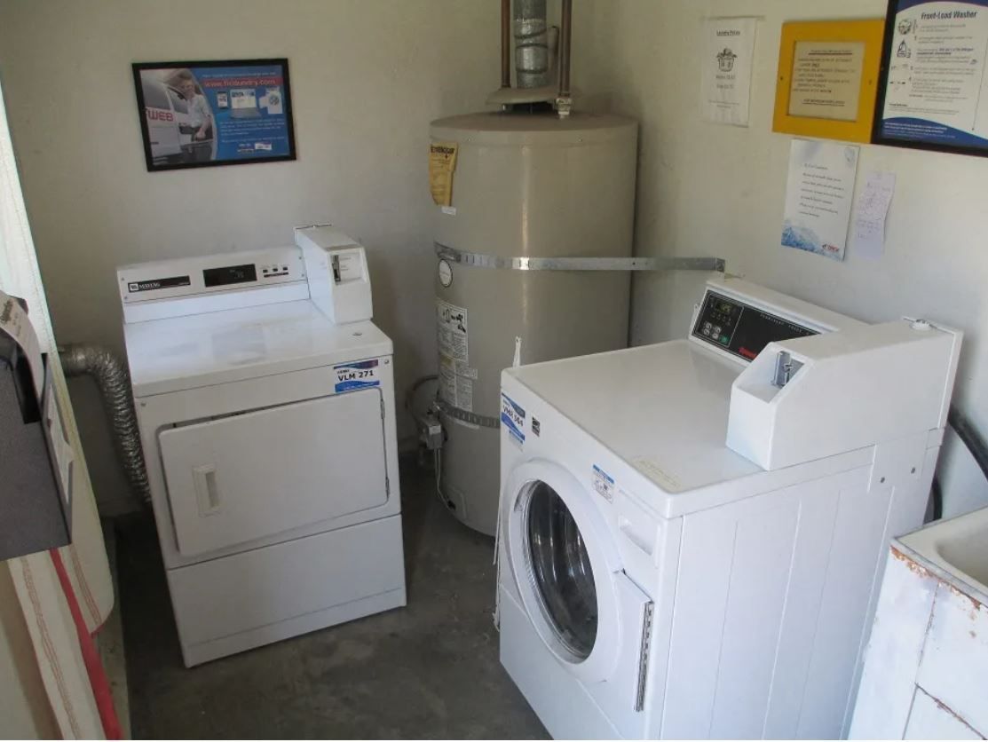 Laundry room with a dryer, washing machine, and water heater.