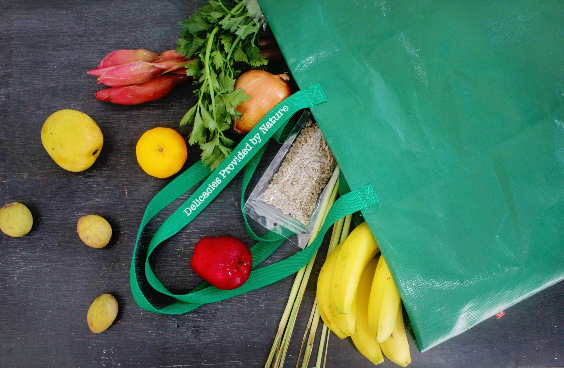 photo of a shopping cart being pushed through the produce section in a grocery store