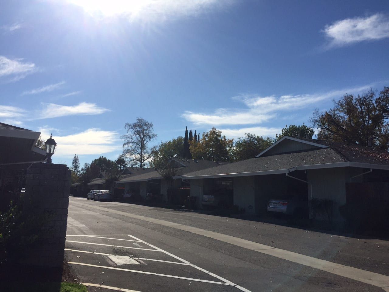 Row of houses with carports under a blue sky.