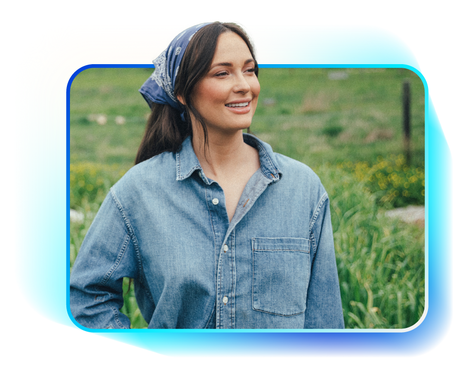 Woman in blue denim shirt and bandana smiles outdoors.