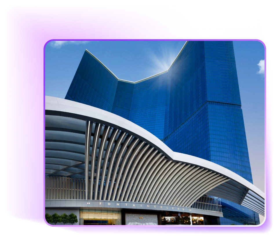 Blue glass skyscraper with a curved white awning on a sunny day.