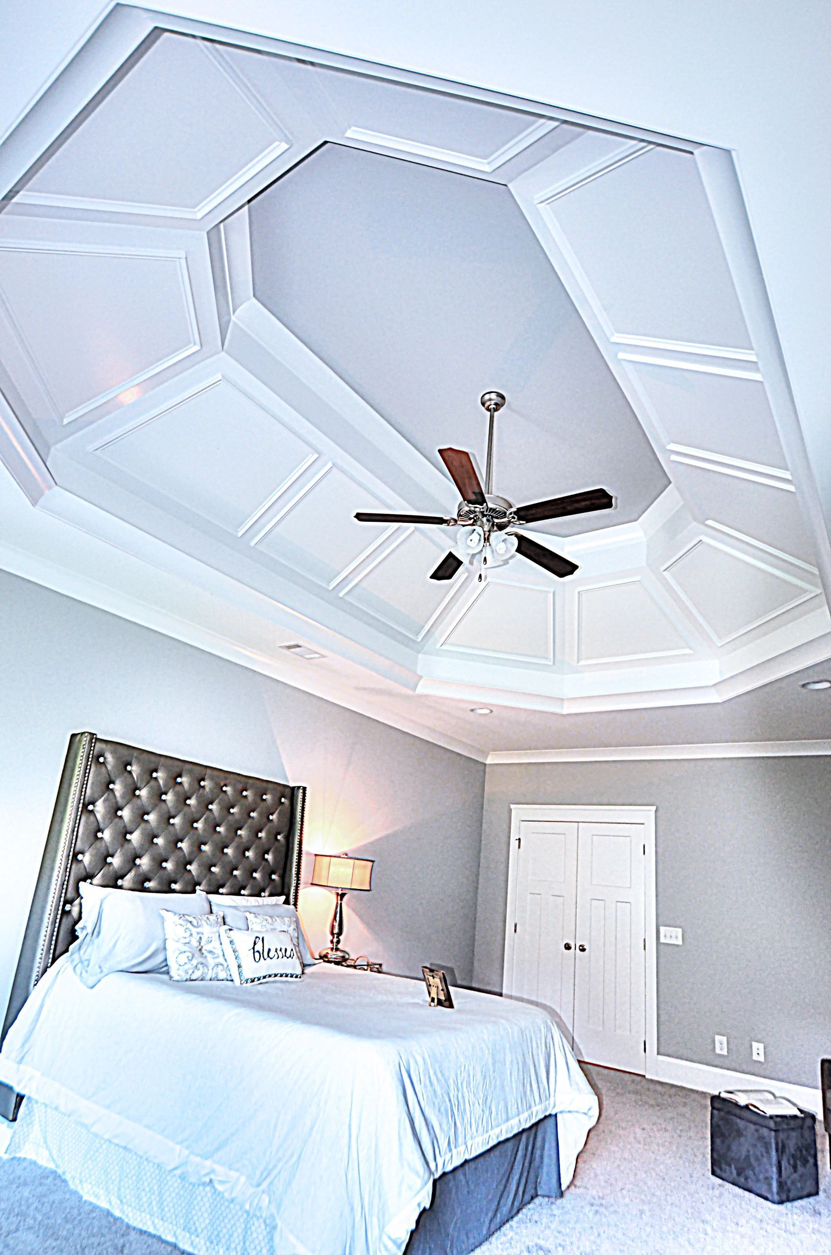 A bedroom with a large bed and a ceiling fan.