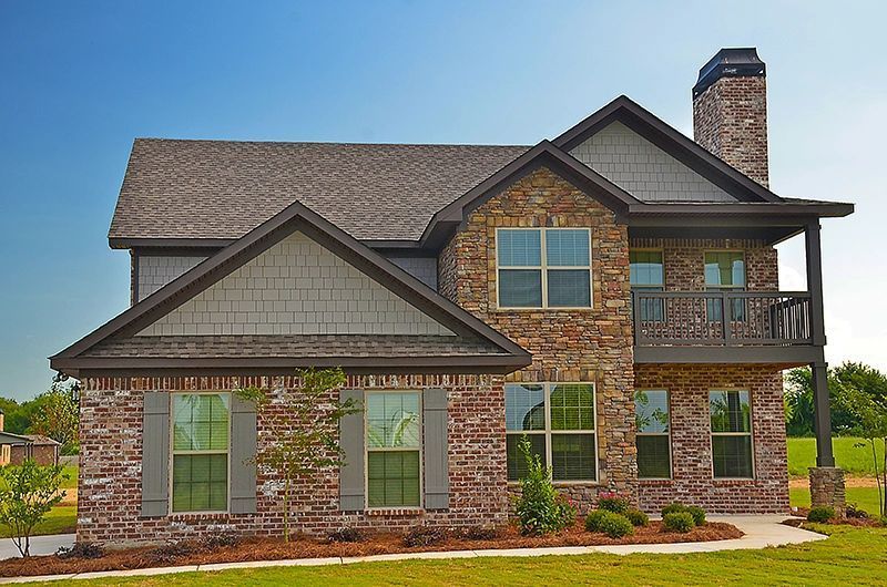 A large brick house with a balcony and a chimney