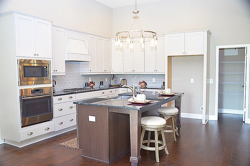 A kitchen with white cabinets and a large island in the middle.